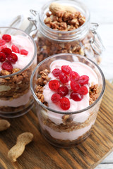 Healthy layered dessert with muesli and berries on table