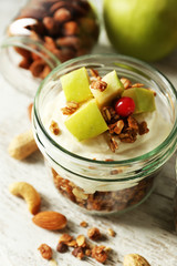 Healthy layered dessert with muesli and fruits on table
