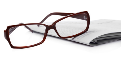 Glasses and newspapers, close-up