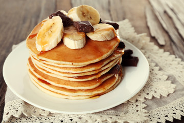Stack of delicious pancakes with chocolate, honey and slices of