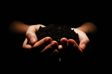 Handful of soil on dark background
