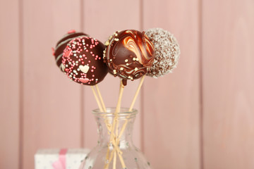 Tasty cake pops on wooden background
