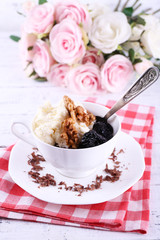 Dessert with prunes in cup with bouquet of roses