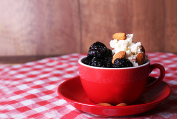 Dessert with prunes and almonds in red cup