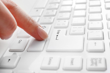 Female hand typing on keyboard, macro view