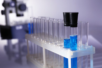Laboratory glassware with blue liquid on gray background