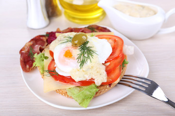 Sandwich with poached egg, tomato and bacon
