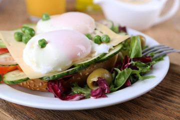 Sandwich with poached eggs, cheese and vegetables