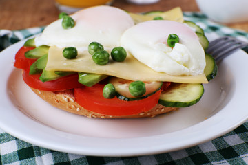 Sandwich with poached eggs, cheese and vegetables