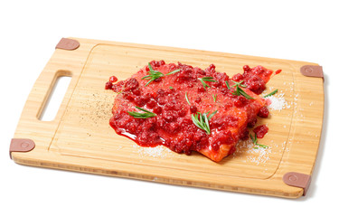 Salmon steak being marinated in salt with rosemary and redberrie
