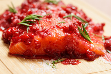 Salmon steak being marinated in salt with redberries