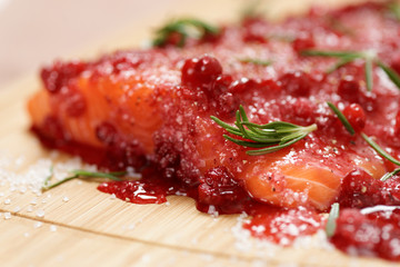 Salmon steak being marinated in salt with redberries