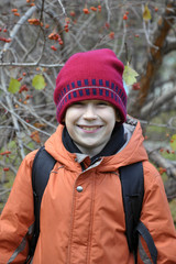 portrait of the joyful teenage boy in the autumn wood.