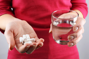 Hands with pills and glass of water