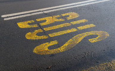 Bus sign with yellow paint on asphalt