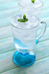 Glasses with ice cubes on wooden table