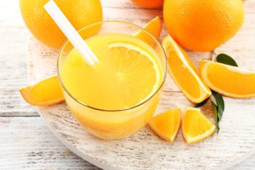 Glass of orange juice with straw and slices