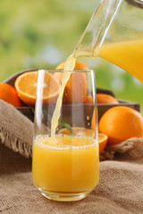 Pouring orange juice from glass carafe,
