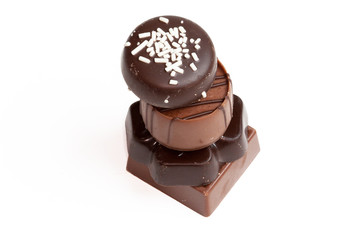 Différents  bonbons en chocolat empilés sur fond blanc