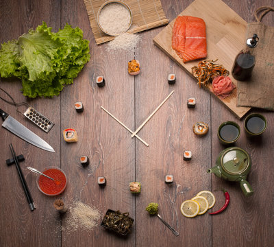 Sushi time in the form of a wall clock on a wooden background