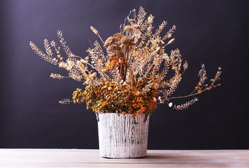 Bouquet of dried flowers in vase on table and dark background - Powered by Adobe