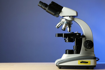 Microscope on table, on color background