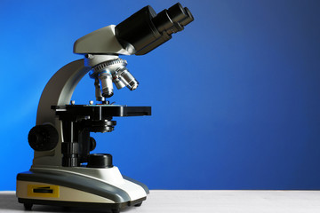 Microscope on table, on color background