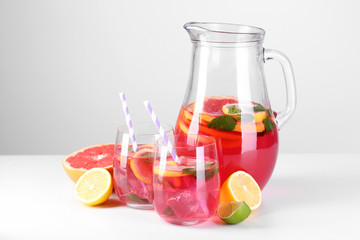 Pink lemonade in glasses and pitcher isolated on white
