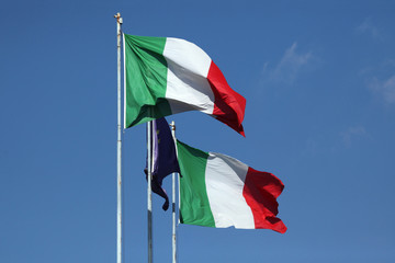 National flags of Italy and a flag of the European Union.