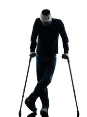 injured man standing with crutches silhouette