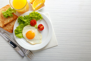 Bacon and eggs on color wooden table background
