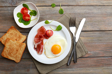 Bacon and eggs on rustic wooden planks background