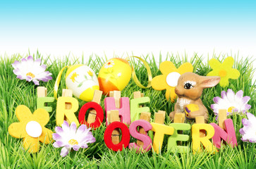 Frohe Ostern - Buchstaben mit Ostereiern, Blüten und Himmel