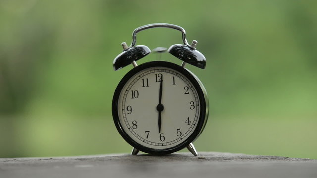 Clock ringing against green background