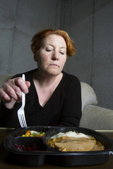 Middle Aged Woman Eating TV Dinner