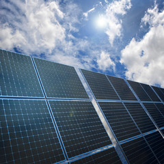 Solar energy panels on nice sky background with white clouds