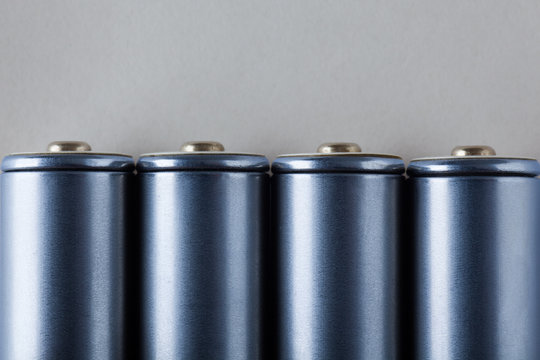 Four AA Blue Batteries on Gray Background