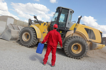 man in red uniform with petrol can at bulldozer back view