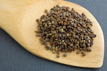 Close view of cardamom seeds on wood spoon