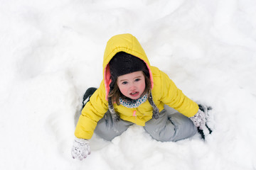 Fototapeta na wymiar A little girl playing in the snow