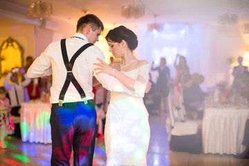Just married couple dancing in front of their unrecognizable fri