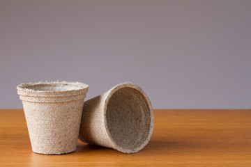 Small peat flowerpots on a wooden table