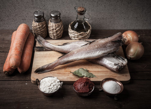 Still life with fish, vegetables and spices on a wooden board. T
