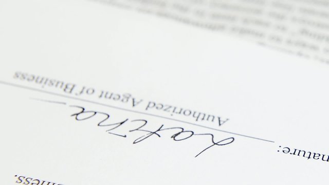 hand puts the signature on the document
