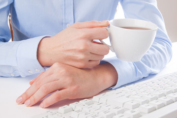 Young woman drinking tea in the workplace