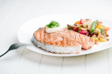 Grilled Salmon with Fresh vegetables on white background