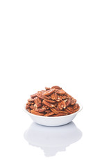 Pecan nut in a white bowl over white background