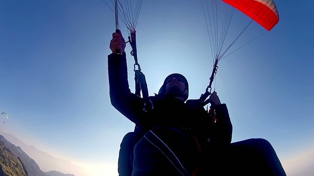 tandem paragliding fly against bright sun