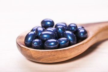 Cod liver oil omega 3 gel capsules isolated on wooden background