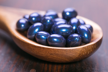 Cod liver oil omega 3 gel capsules isolated on wooden background